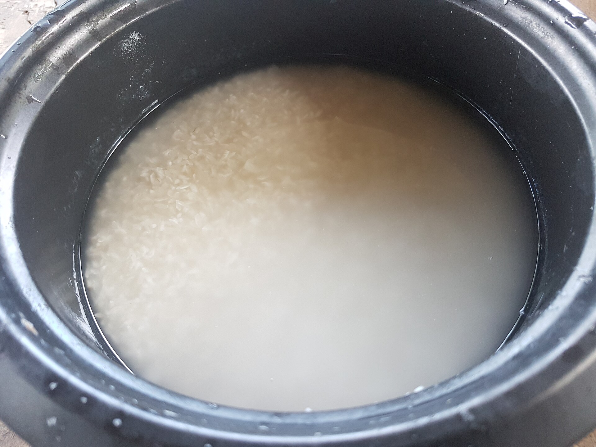 清水中浸泡的米粒,水色因淘洗略显浑白