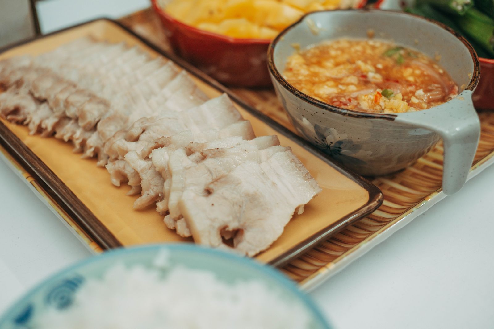 切好的熟猪肉片与米饭，展示加肉油糯米饭的肉香搭配